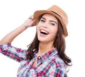 Smiling woman in a plaid shirt and brown hat.